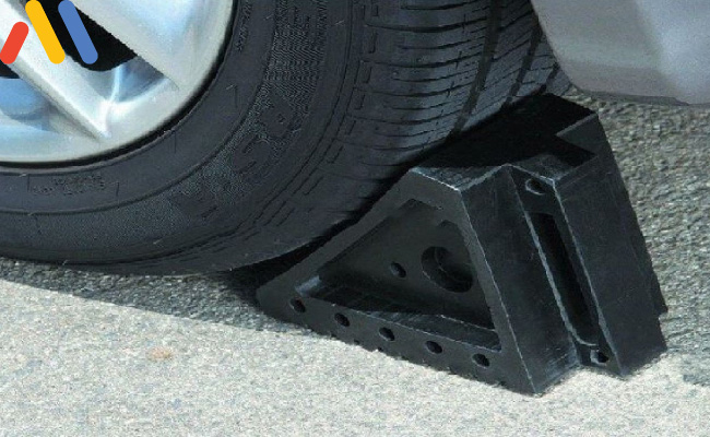 Cách thay lốp ô tô - Chèn trước bánh xe để giữ cho xe cố định