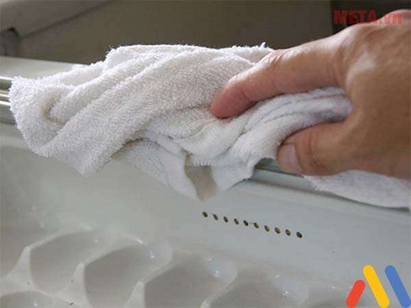 Cách rã đông tủ đông: Dùng khăn để gỡ các tảng băng dễ dàng hơn
